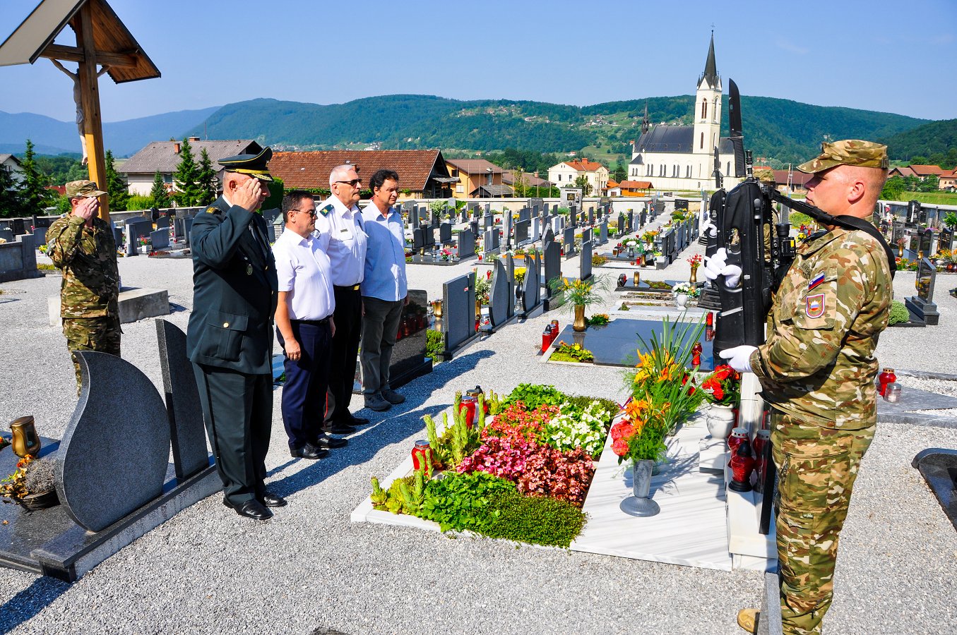 Polaganje cvetja na pokopališču v Prečni