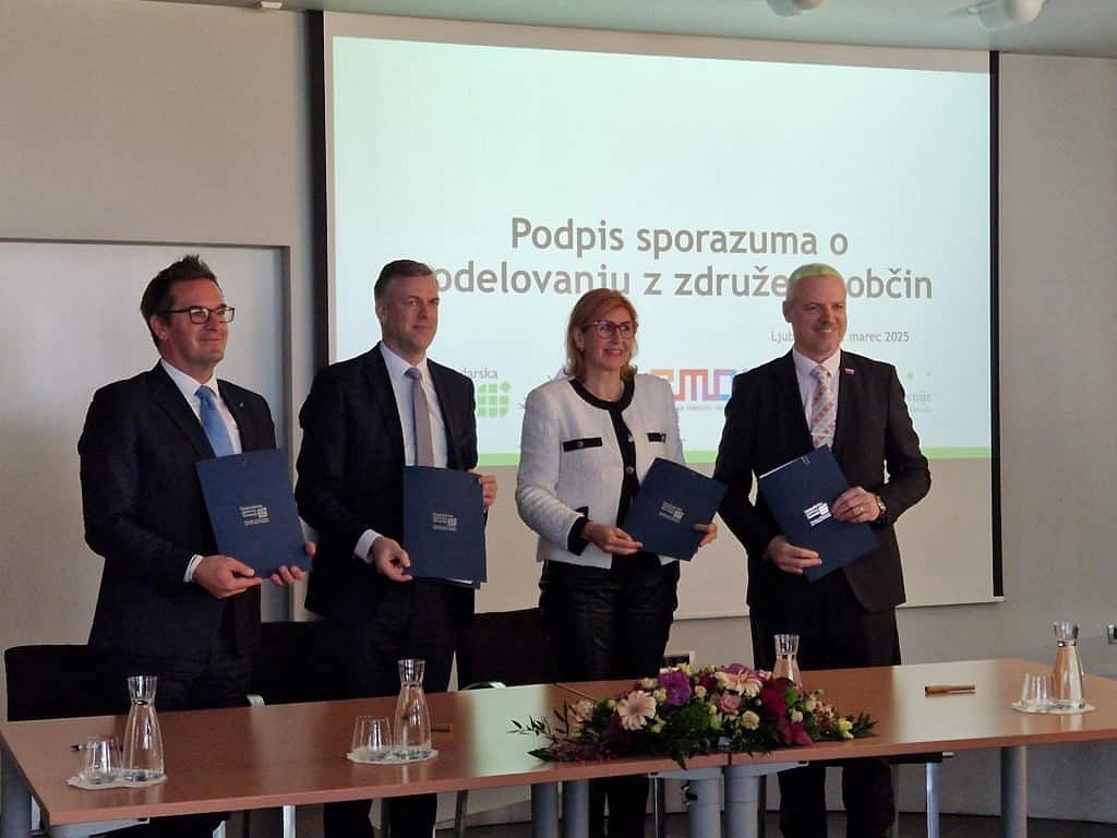 predstavniki podpisali stojijo in v rokah držijo mape GZS in predstavniške organizacije občin  podpisali partnerski sporazum »Zavezništvo za razvoj«