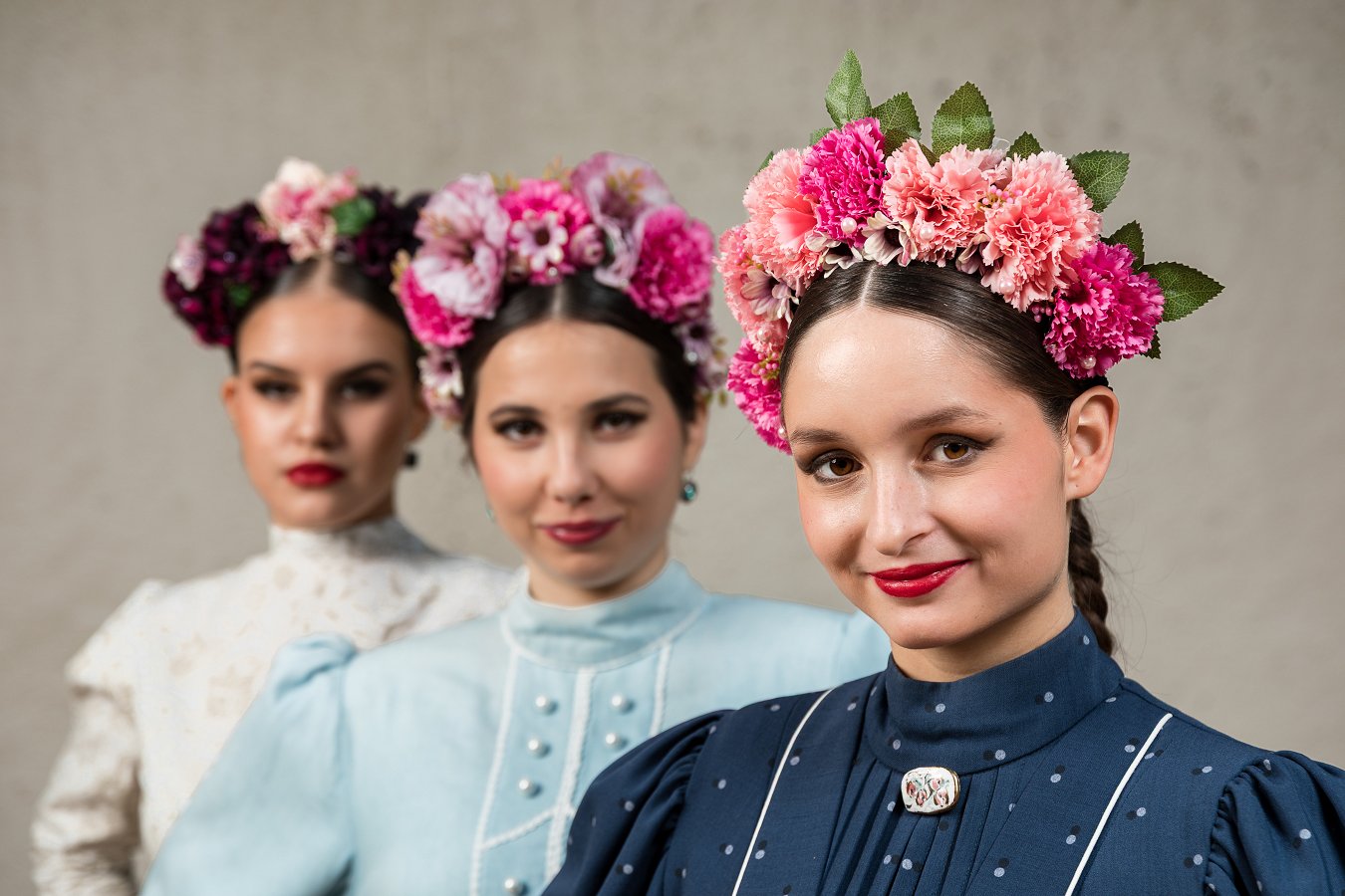 tri dekleta s cvetličnimi venci v laseh